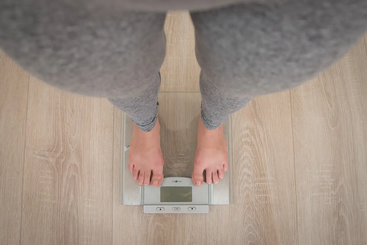 Woman on scales losing weight through hypnotherapy